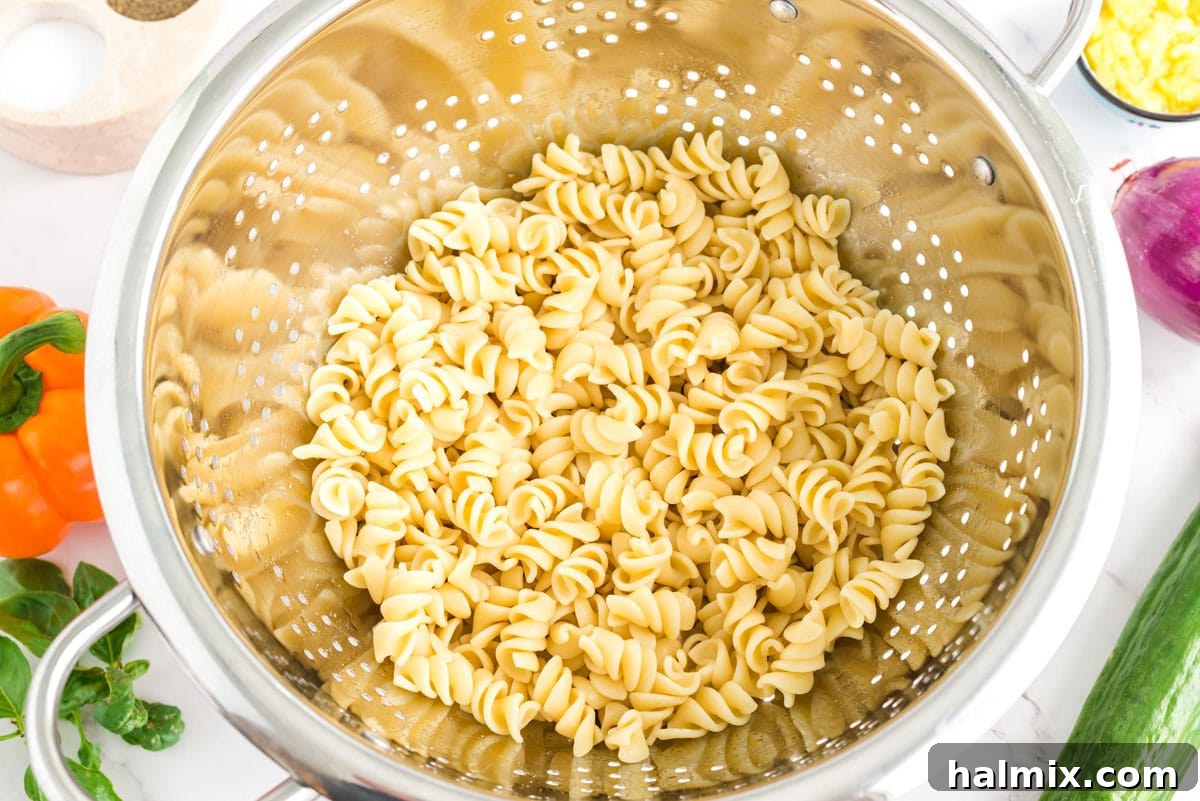 Cooked rotini pasta in a colander, freshly rinsed