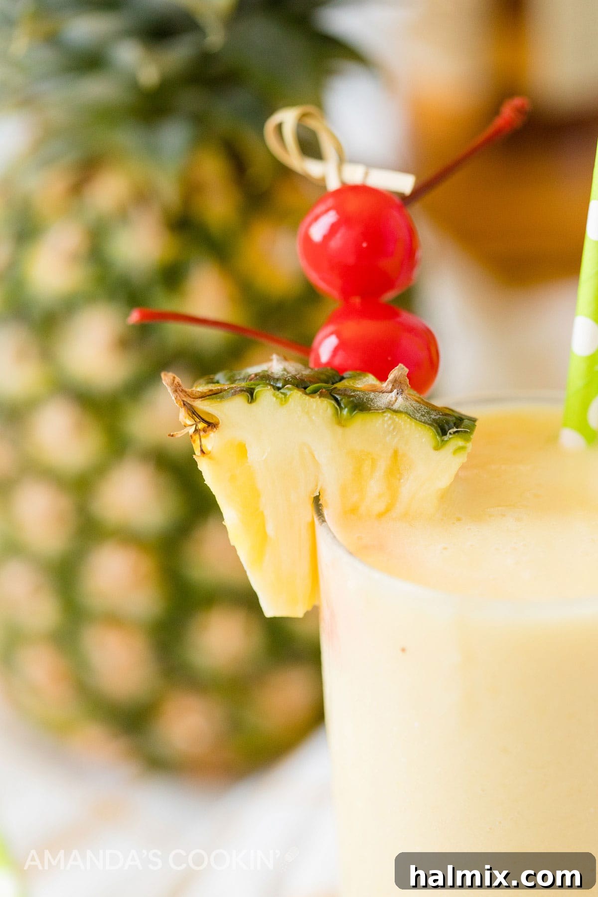 A close-up view of a refreshing pineapple rum slush cocktail, beautifully garnished with a bright red maraschino cherry and a fresh pineapple wedge, highlighting its vibrant appeal.