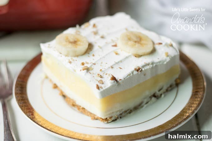 A single slice of Banana Cream Lush on a white plate, showing its distinct layers.