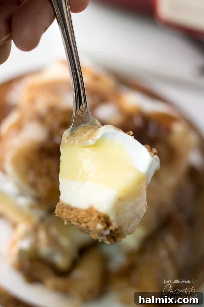 A fork taking a bite of the layered Banana Cream Lush dessert, showcasing its distinct layers.