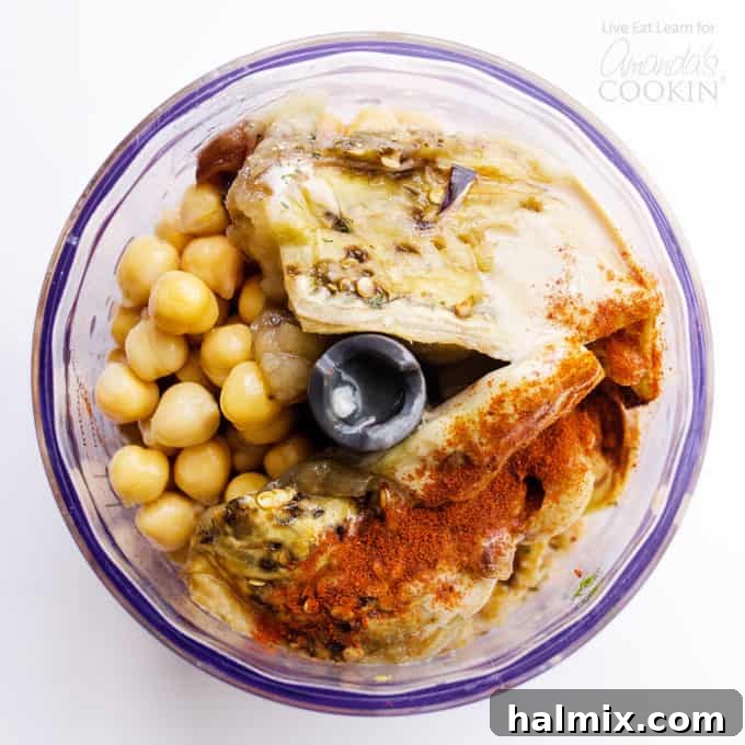 Simple Ingredients for a Flavorful Baba Ganoush Hummus: Eggplant, Chickpeas, Tahini, Lemon, and Spices Ingredients for Baba Ganoush Hummus being prepared in a food processor