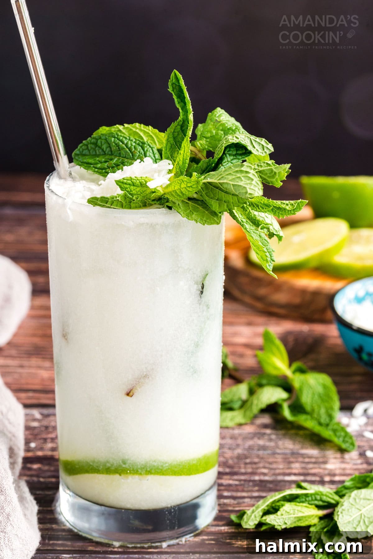 A vibrant glass of Coconut Mojito, garnished with fresh mint and a lime wheel, beckons for a refreshing sip on a hot summer day.