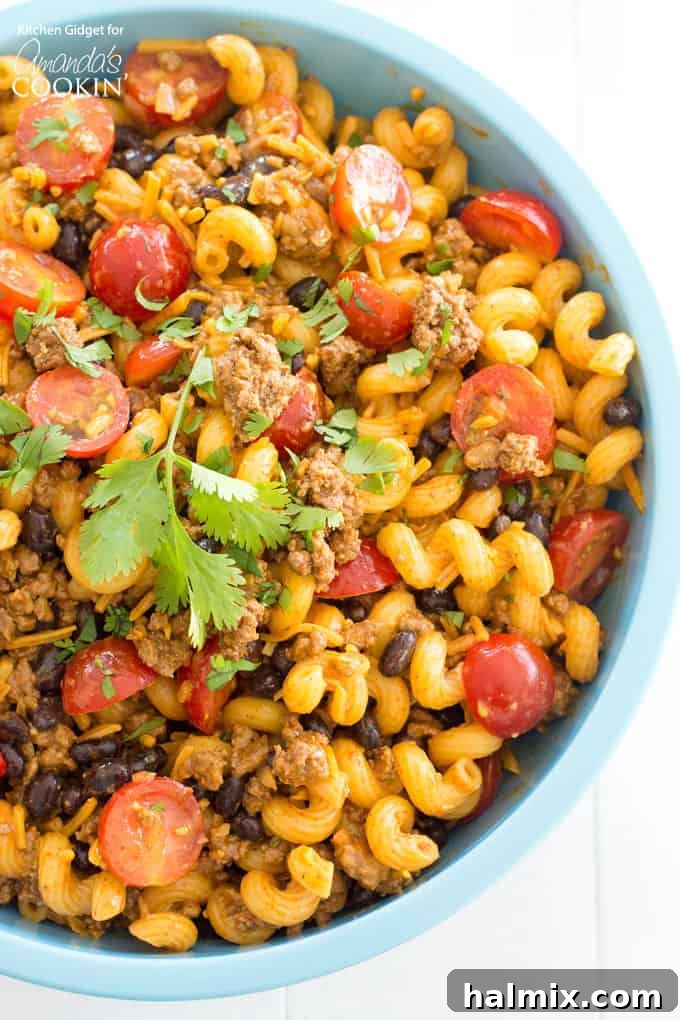 This vibrant taco pasta salad is loaded with seasoned ground beef, juicy tomatoes, black beans, and plenty of cheese. It's a fantastic cold pasta salad for your next party, potluck, or summer gathering! Delicious and colorful taco pasta salad, ready to serve