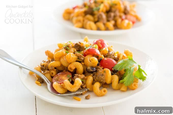 Enjoy a generous serving of our homemade taco pasta salad, perfectly portioned for a delightful meal. This cold pasta salad is a versatile dish for any occasion! A serving of taco pasta salad on a white plate