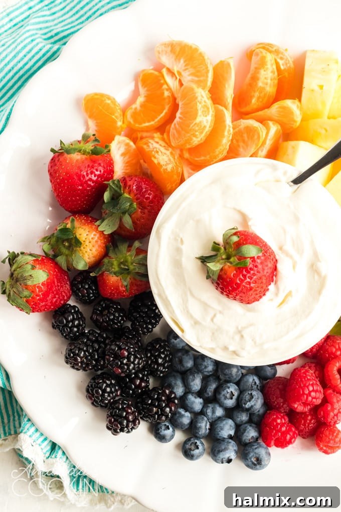 WHITE PLATE FULL OF FRUIT WITH FRUIT DIP IN THE MIDDLE