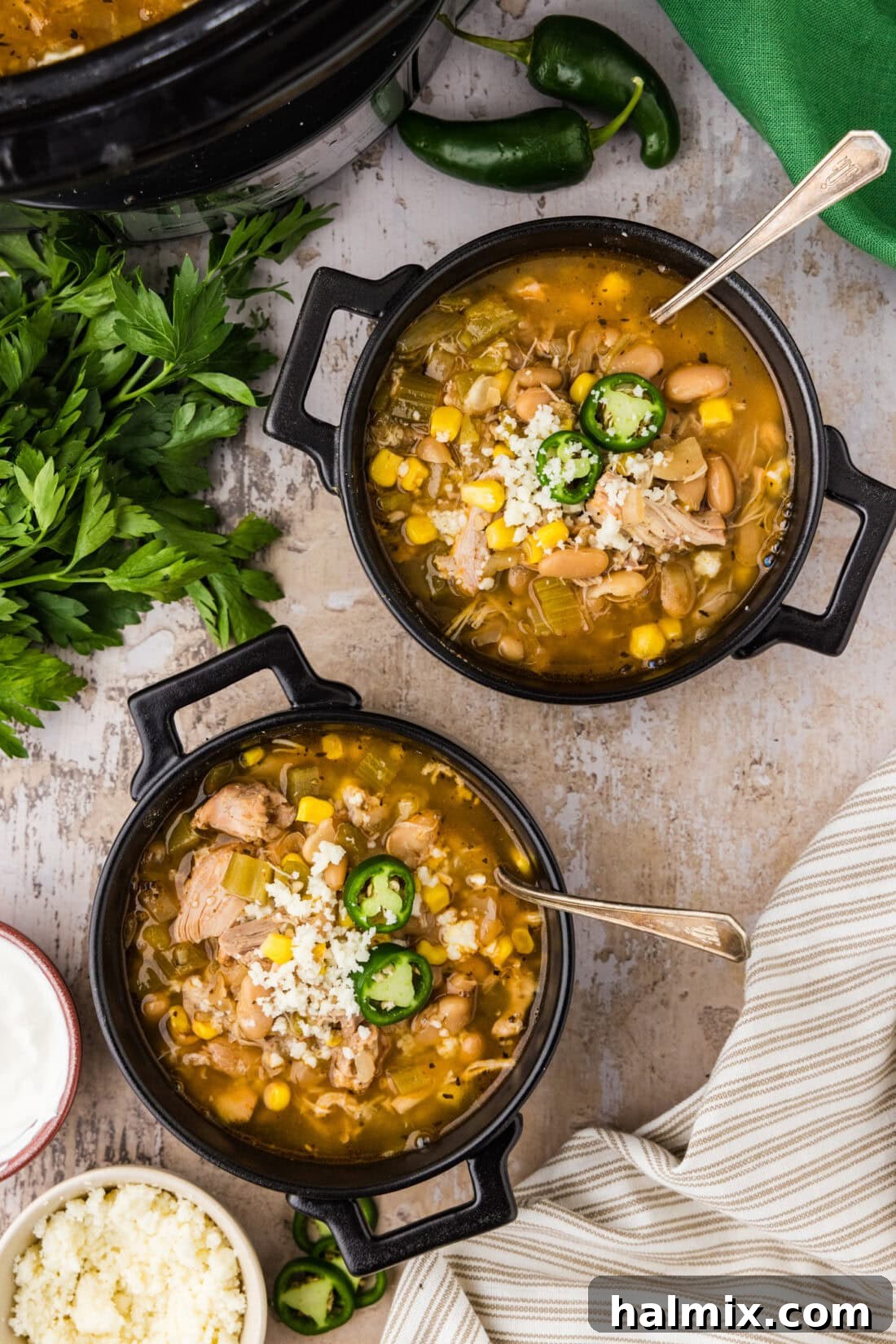 Two bowls of Crockpot White Chicken Chili, garnished with fresh cilantro