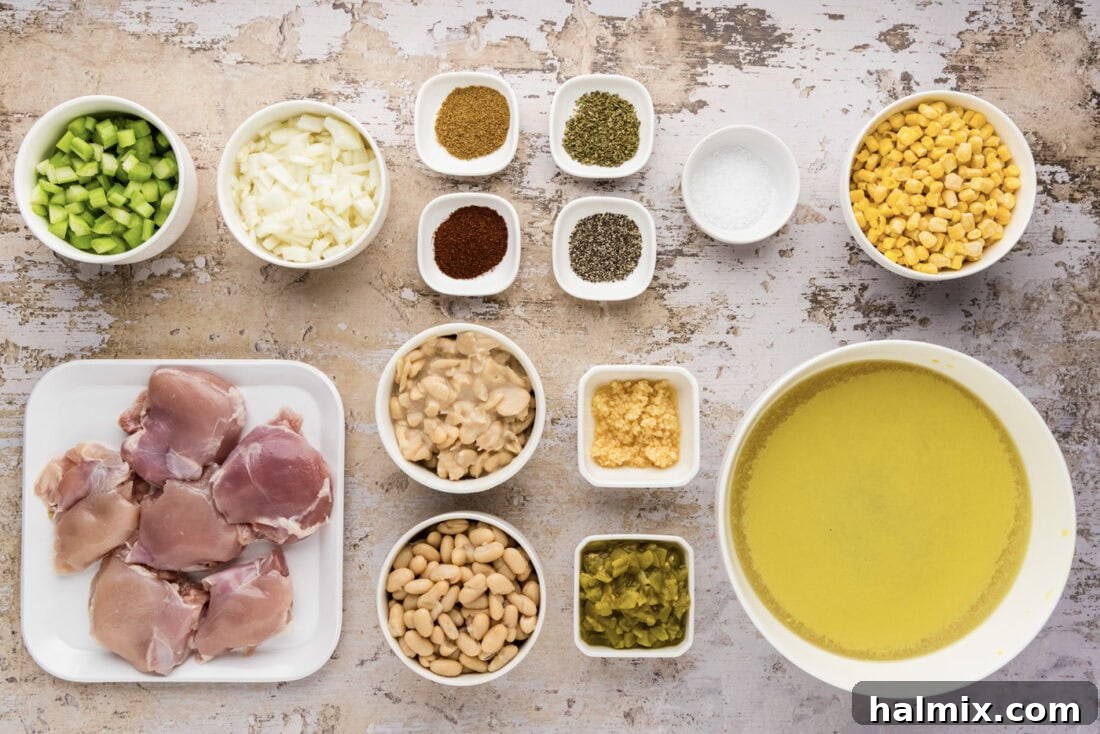 A variety of ingredients for Crockpot White Chicken Chili laid out on a white surface