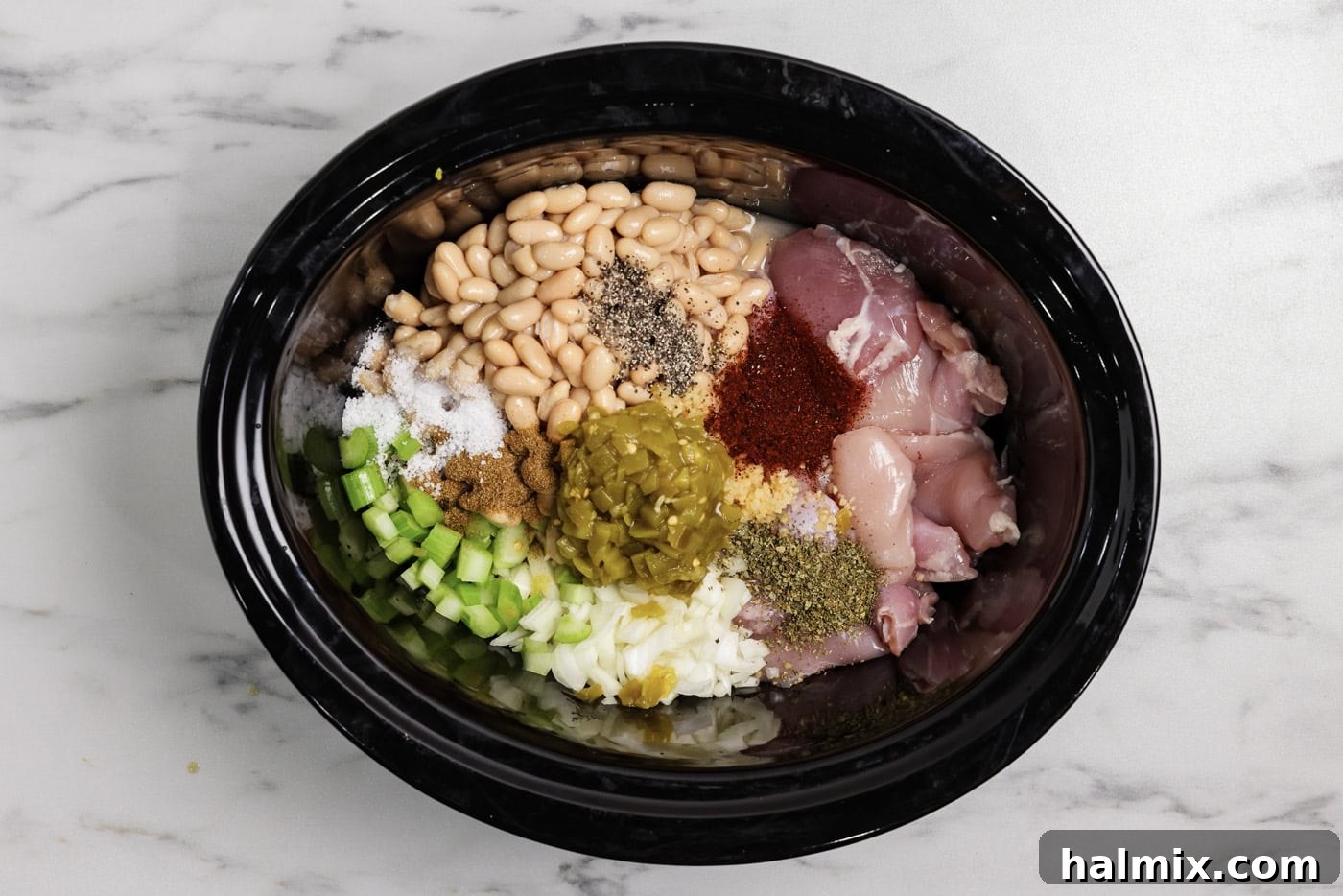 white chicken chili ingredients in the crock of a slow cooker