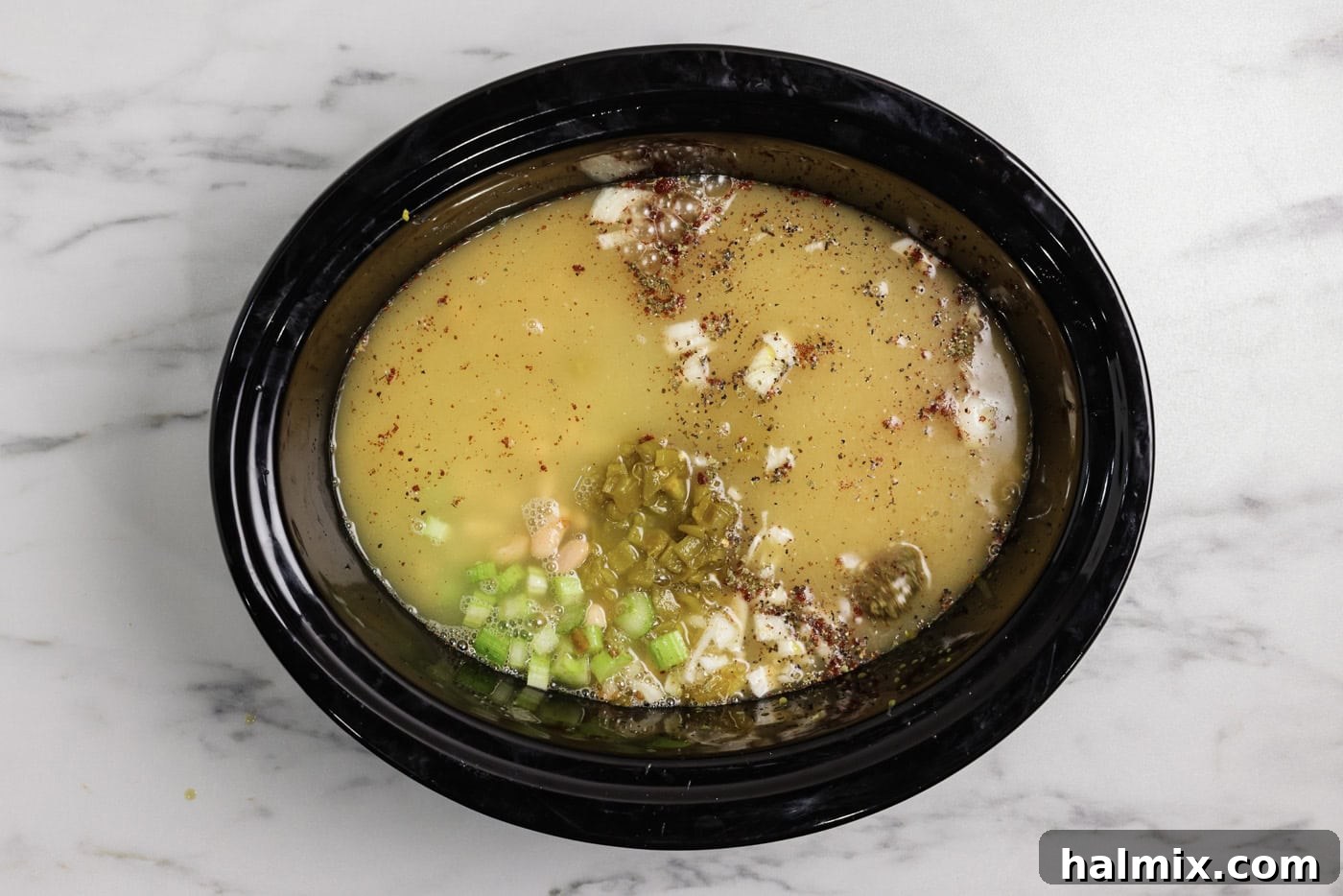 chicken broth added to crockpot with white chicken chili ingredents