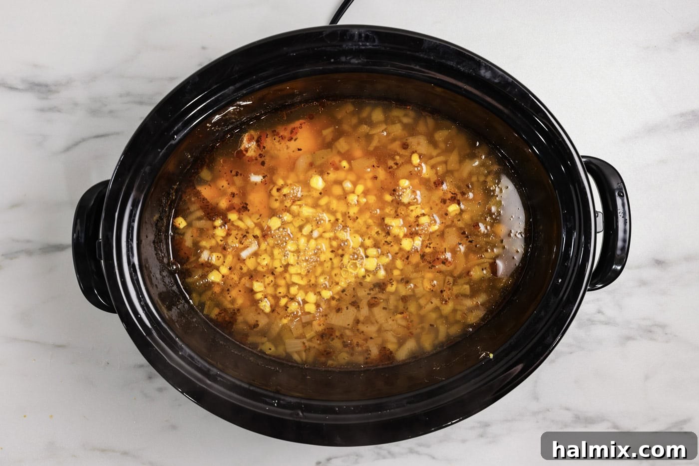 cooked white chicken chili in a slow cooker, with corn added