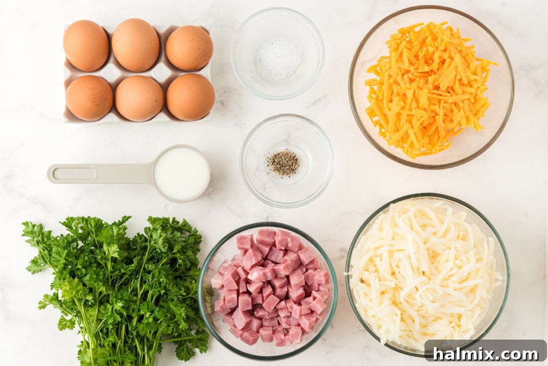 All the fresh ingredients laid out on a cutting board, including diced ham, shredded cheese, eggs, hash browns, and parsley, ready for assembly.