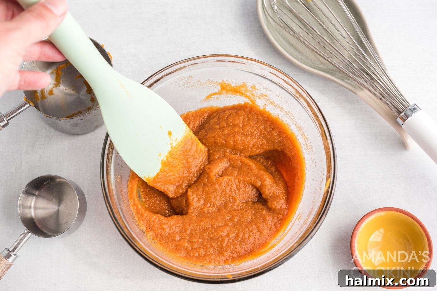 pumpkin pie filling in a mixing bowl with spoon