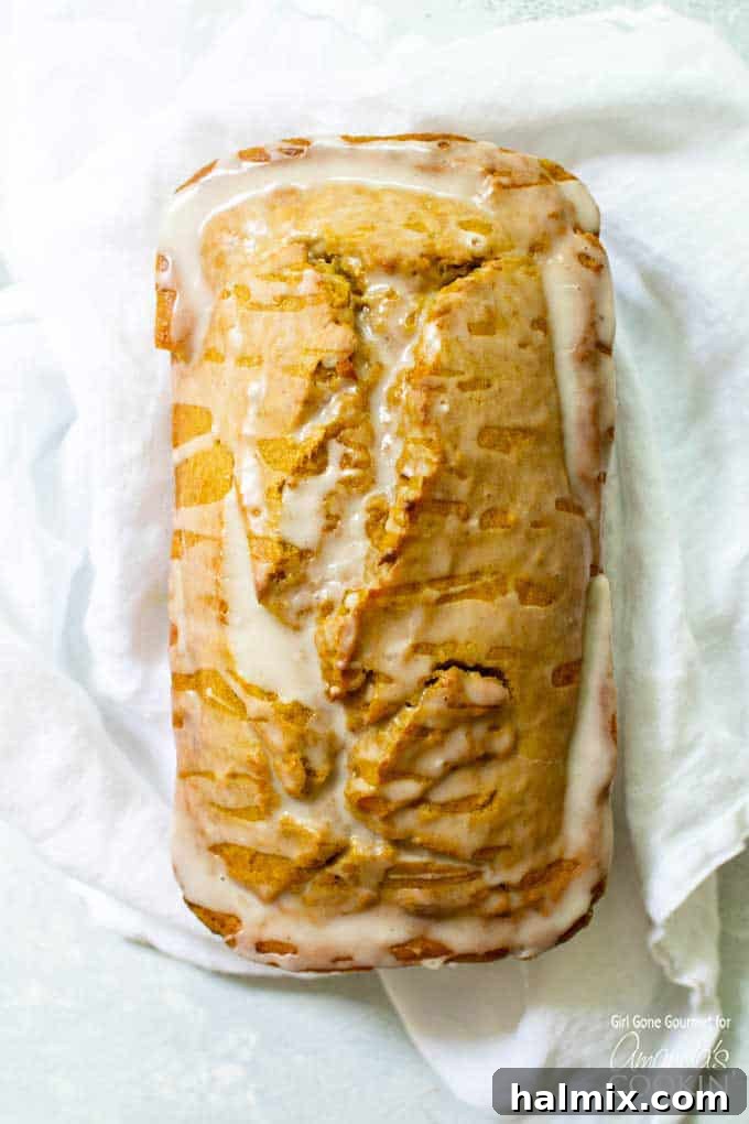 Easy pumpkin bread with maple glaze Moist pumpkin bread loaf with a generous drizzle of maple glaze, a perfect fall treat.