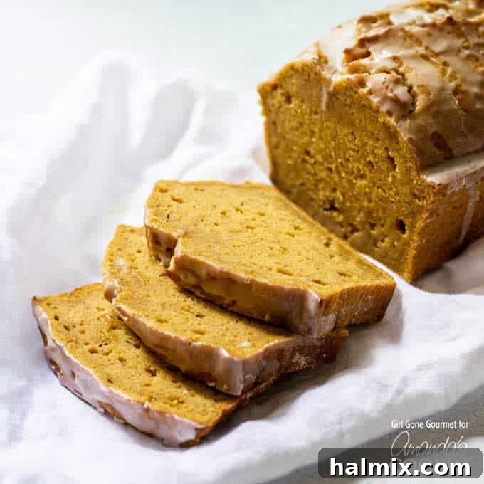 This pumpkin bread is an easy baking project to jump-start the fall season. The maple glaze drizzled on top makes a great treat for breakfast or dessert. Close-up of a sliced pumpkin bread loaf revealing its tender, moist interior and golden crust, generously topped with maple glaze.