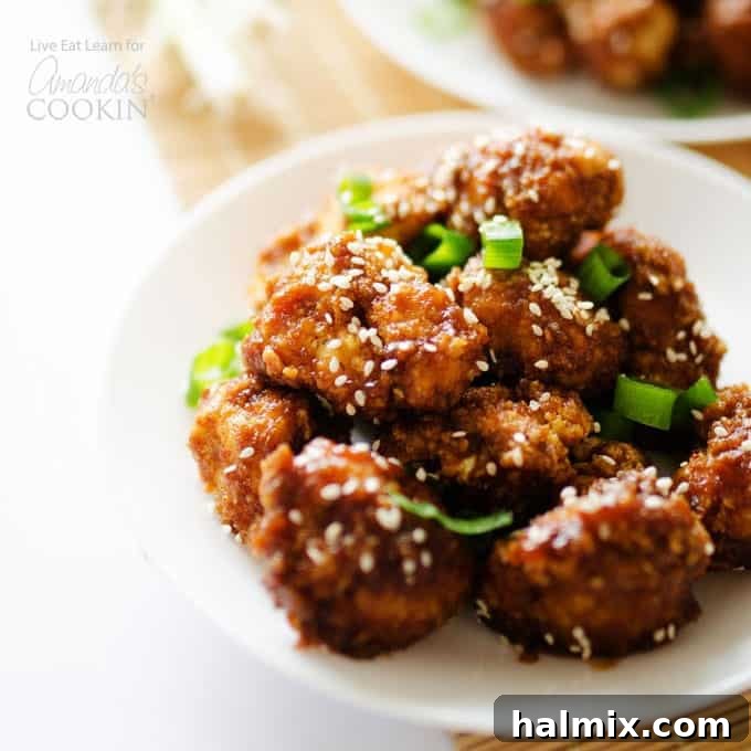 Sticky Cauliflower on a plate, garnished with green onions.