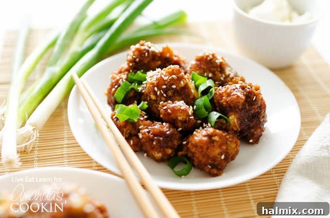 Sticky Garlic Cauliflower served with chopsticks on a white plate, ready to be enjoyed.