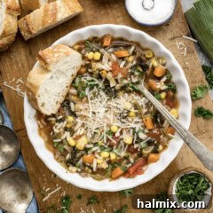 Bowl of Vegetable Rice Soup with bread to the side