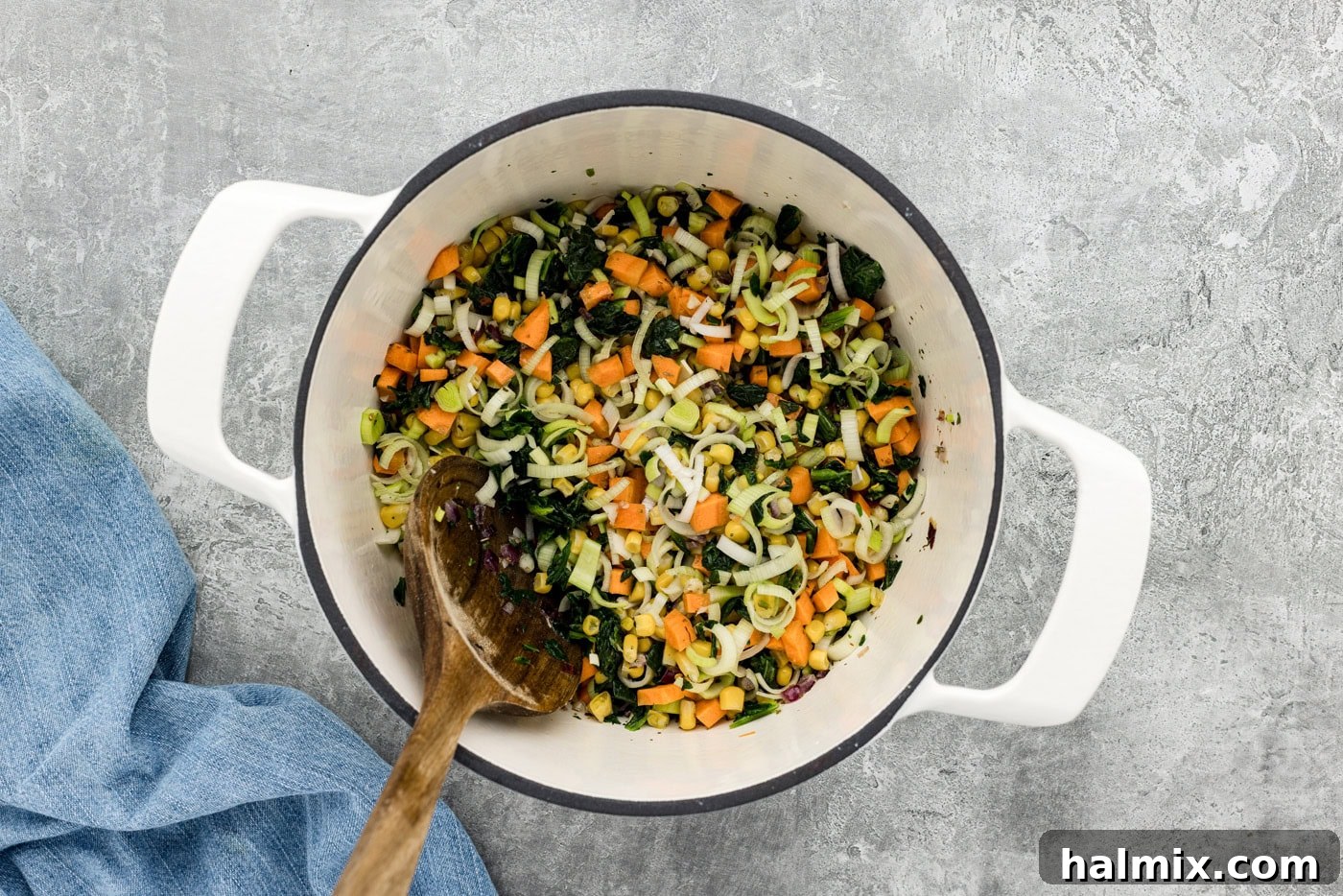 various vegetables mixed together in a pot with a spoon, ready for broth