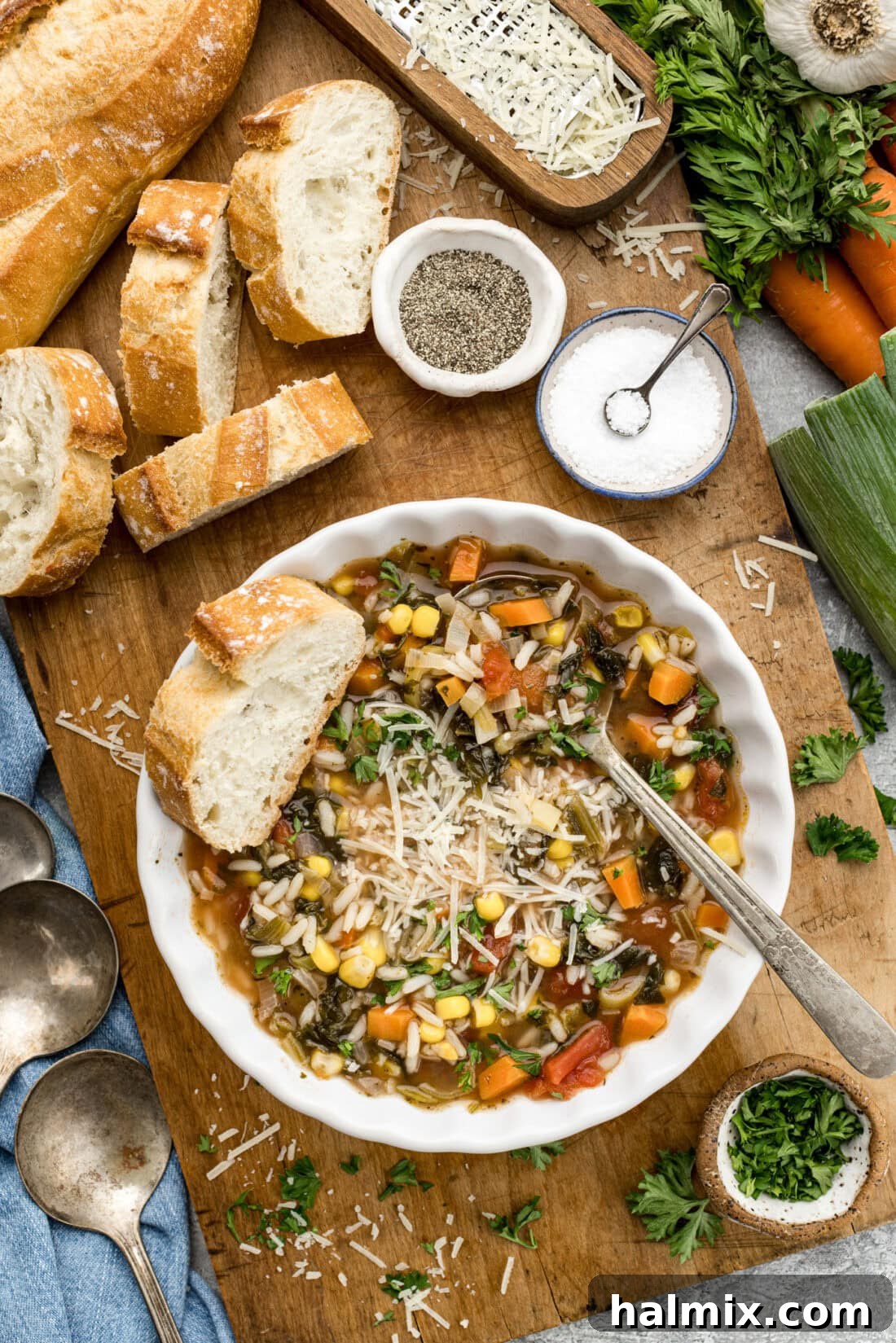 Garden Harvest Rice Soup 10 Bowl of Vegetable Rice Soup surrounded by sliced bread, salt, pepper, and fresh vegetables