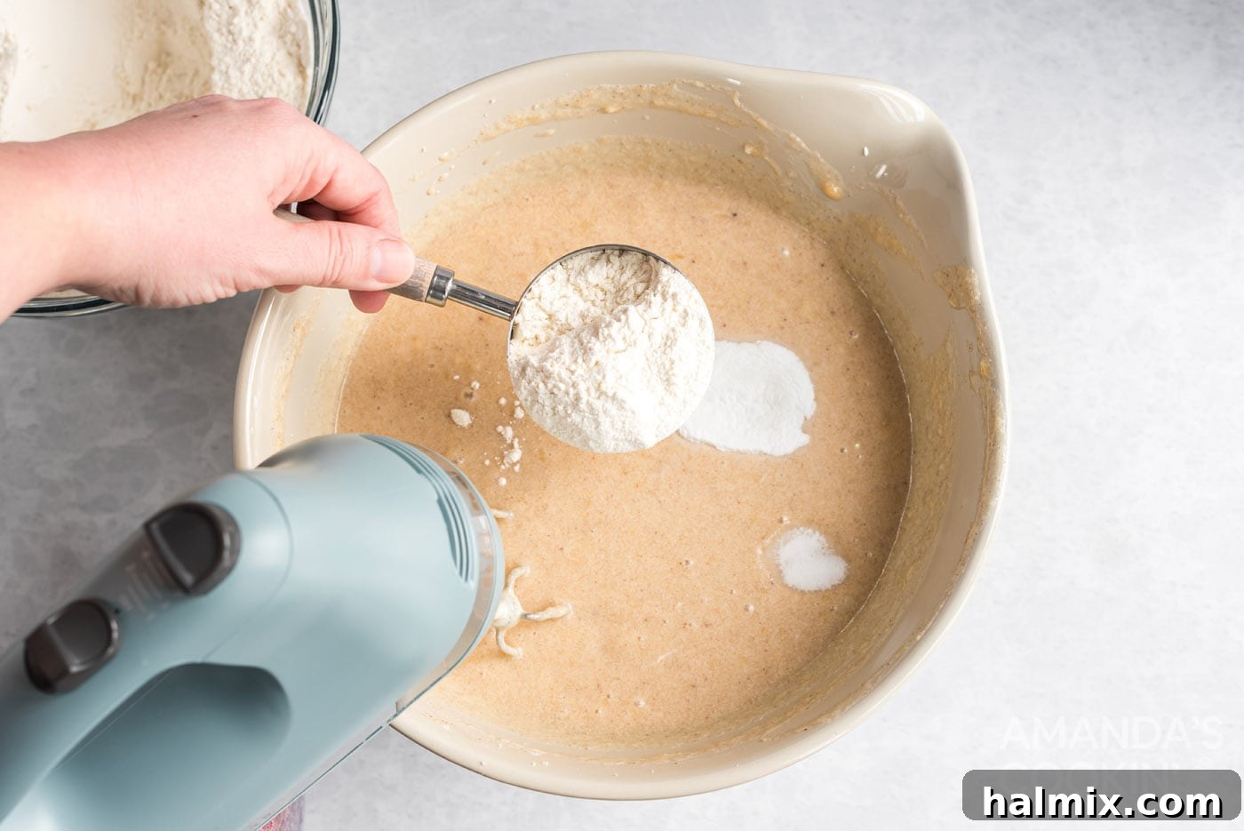 adding flour to bowl