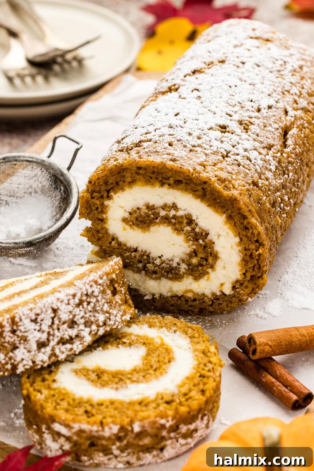 Pumpkin Cake Roll intricately cut into several slices on a wooden board, beautifully displaying the cream cheese swirl.