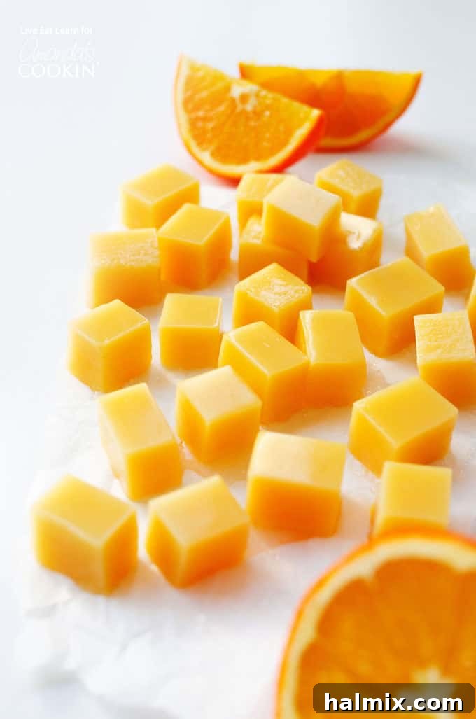 Homemade Orange Creamsicle Gummies: A naturally sweet and fun treat for all ages. #gummies #creamsicle #homemade #orange #snacks #candy #healthysnacks Vibrant orange creamsicle gummies arranged with fresh orange slices, highlighting their homemade appeal and natural color.
