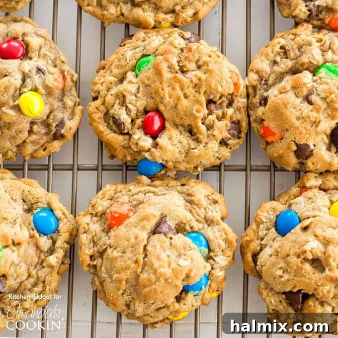 Monster Cookies: Irresistible peanut butter and oatmeal cookies packed with chocolate chips and colorful M&M's – a fun and easy recipe for everyone! #monstercookies #m&ms #cookierecipes #bestdessertrecipes #chocolate #peanutbutter #peanutbuttercookies #oatmeal #oatmealcookies overhead photo of cookies on cooling rack, perfectly golden and studded with M&M's