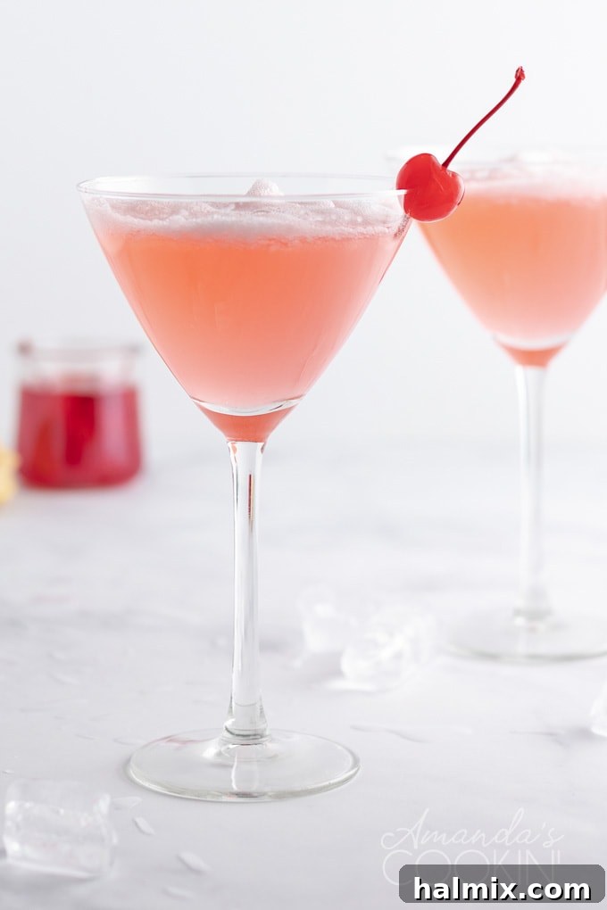 A vibrant Pink Lady Cocktail in a martini glass, featuring a frothy texture and a delightful sweet-and-tart taste, ideal for special occasions. pink lady cocktail in martini glass