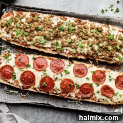 Two French Bread Pizzas, one topped with pepperoni and one topped with sausage and peppers