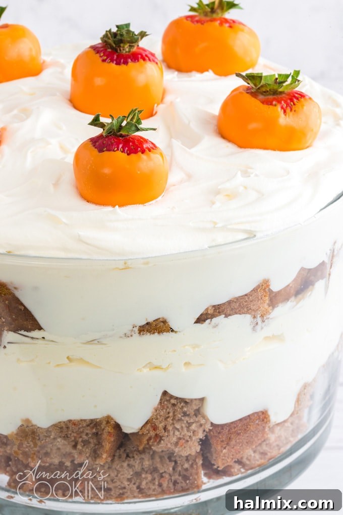 Close-up view of a carrot cake trifle showcasing individual layers of cake, cream cheese frosting, and pudding, ready to be served.