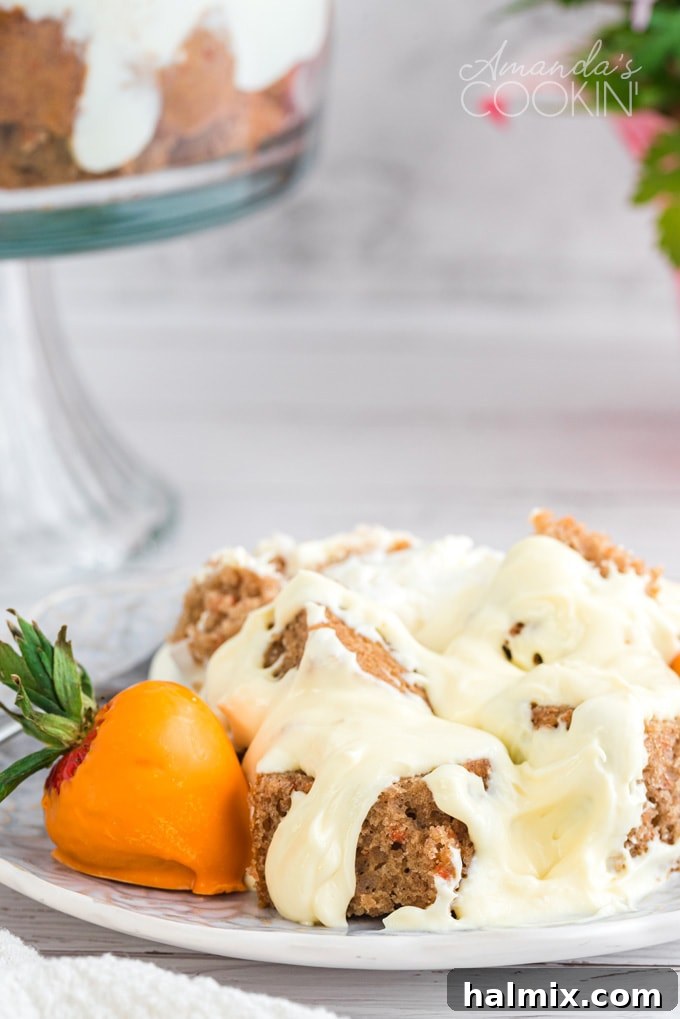 A beautiful individual serving of carrot cake trifle on a plate, garnished with a strawberry carrot and ready to eat.