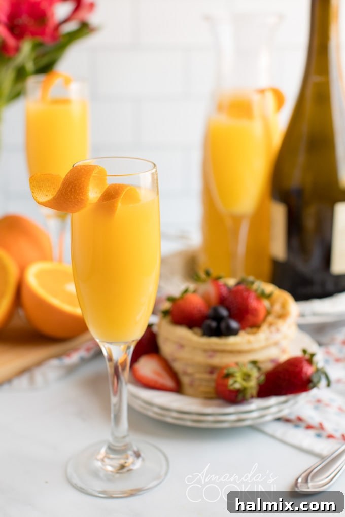 Three Mimosas on a table with waffles in the background, ready for brunch
