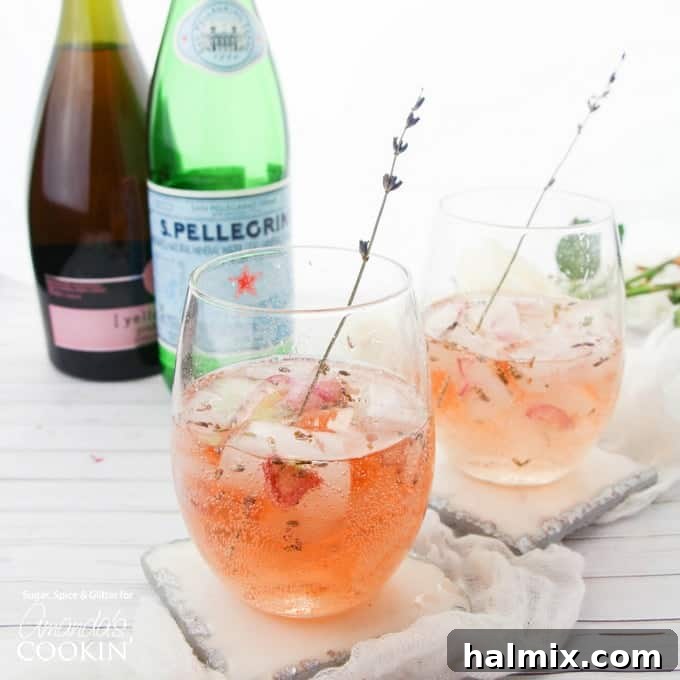 Lavender Rose Spritzer: A visually stunning cocktail for any elegant celebration. Two glasses of Lavender Rose Spritzer, showcasing the beautiful rose petals and lavender buds in the ice