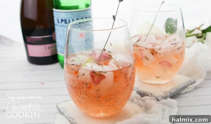 Detail of Lavender Rose Spritzer showcasing floral garnish and sparkling rosé. Close-up of a Lavender Rose Spritzer in a wine glass with a lavender sprig garnish