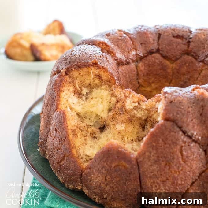 Warm Monkey Bread with a piece pulled out, showcasing its sticky, gooey interior