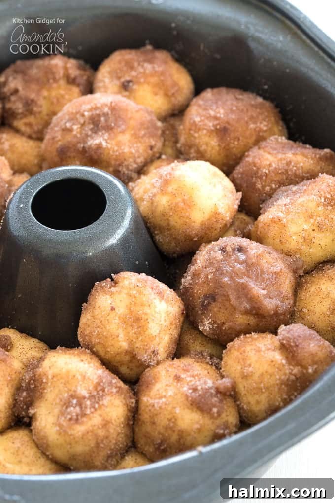 Small dough balls coated in cinnamon sugar, layered in a Bundt pan ready for baking
