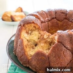 Warm Monkey Bread with a piece pulled out, showcasing its sticky, gooey interior