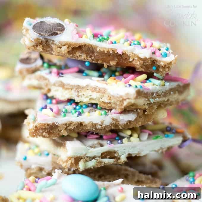This Easter crack is a festive Saltine Toffee. An easy-to-make recipe using simple pantry ingredients like white chocolate, sprinkles, and Easter candies. #easterdessert #easter #eastercandy #saltinetoffee #saltinecrack #whitechocolate #holidaydessert stack of easter themed cracker toffee