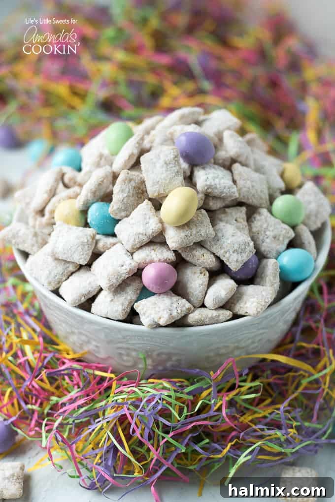 Colorful Easter Muddy Buddies snack on a white plate with pastel candies