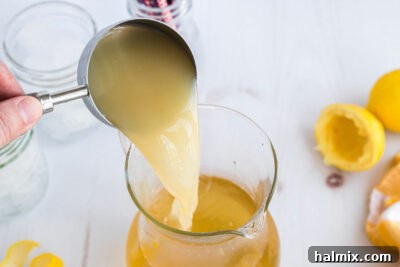 Lynchburg's Golden Refreshment 14 Pouring lemon juice into a pitcher to mix with other cocktail ingredients.