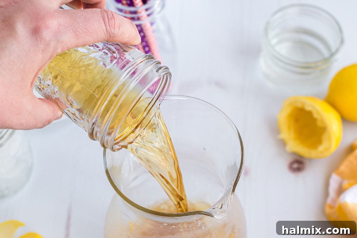 Lynchburg's Golden Refreshment 7 Adding Jack Daniel's whiskey to a pitcher, combining the spirits.