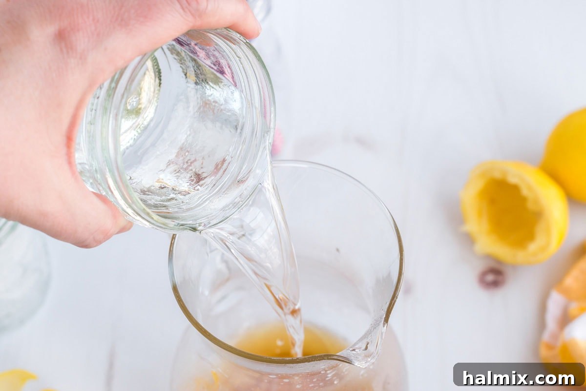 Lynchburg's Golden Refreshment 8 Adding Triple Sec to a pitcher, enhancing the citrus notes and sweetness.