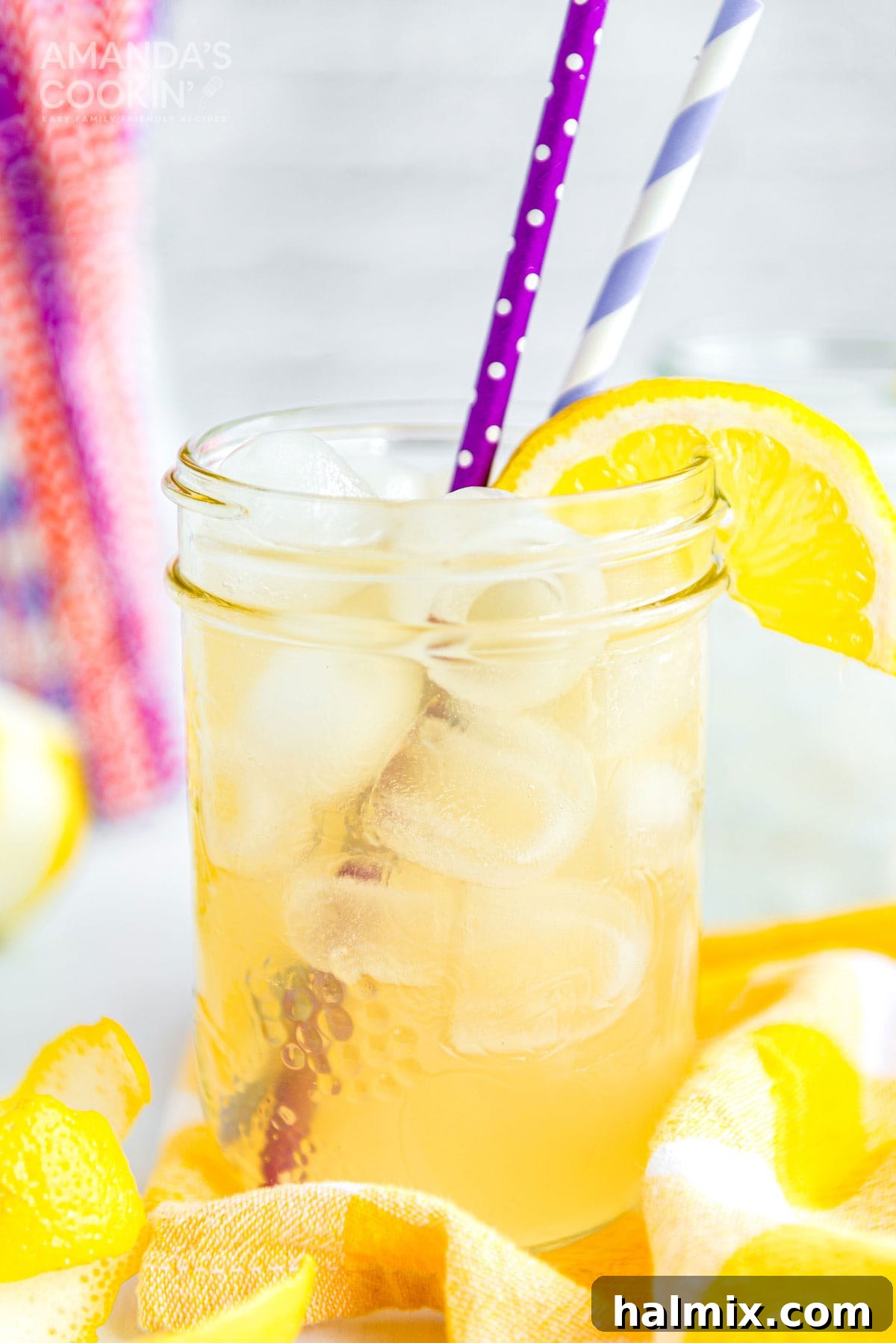 Lynchburg's Golden Refreshment 10 A mason jar glass of Lynchburg lemonade with straws and a lemon garnish, ready to be served.
