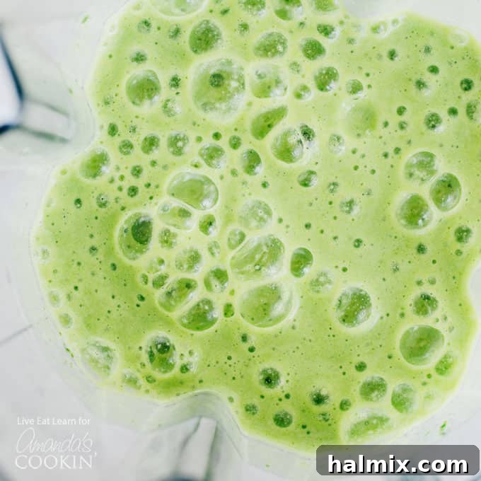 Blend your way to health with this Cucumber Tropical Smoothie, packed with nutrient-rich fruits and greens for a refreshing, energy-boosting start to your day. #smoothieingredients #healthybreakfast #tropicalvibes #cucumberbenefits Cucumber tropical smoothie ingredients being blended in a high-speed blender, showing vibrant green and yellow hues.