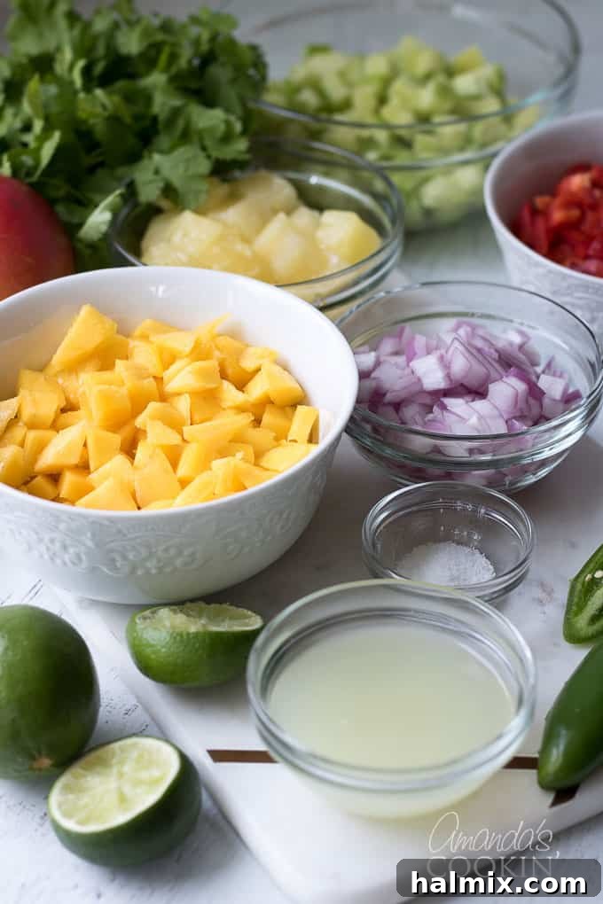 mangoes, cucumber, red bell pepper, pineapple, cilantro and jalapeno in bowls