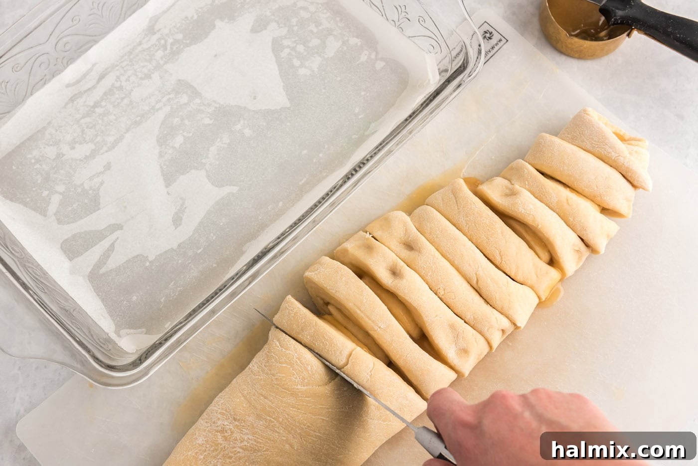 Cutting the dough log into even sections to form the sweet rolls.