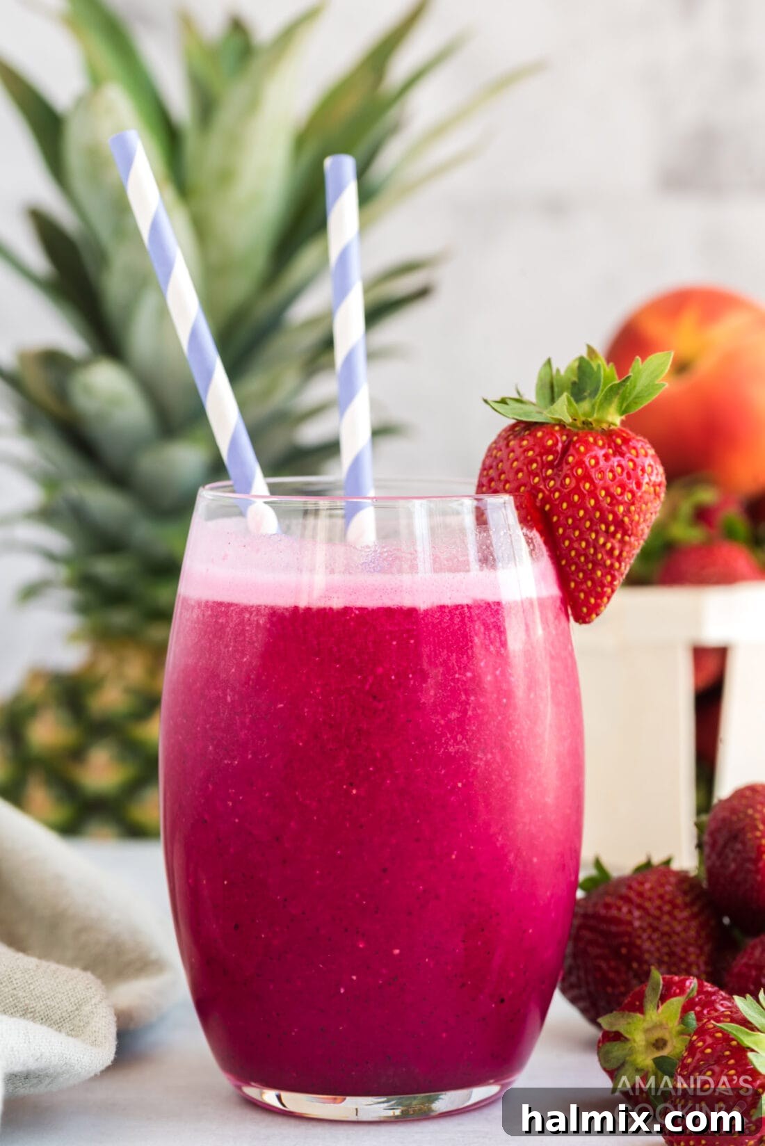 Vibrant rosé wine slushie garnished with a fresh strawberry and mint, ready for a summer party.