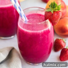 A chilled glass of vibrant rosé wine slushie, garnished with fresh berries and a straw.
