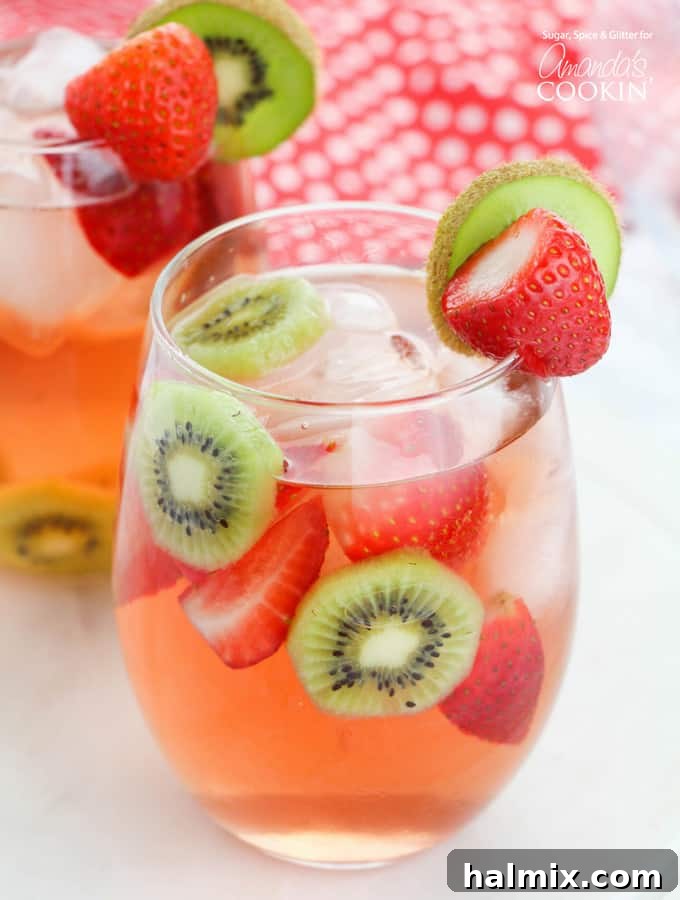 Vibrant Strawberry Kiwi Sangria in a glass pitcher, garnished with fresh fruit.