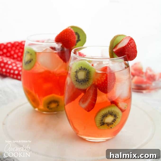 Two glasses of Strawberry Kiwi Sangria ready to be served, garnished with fresh fruit slices.
